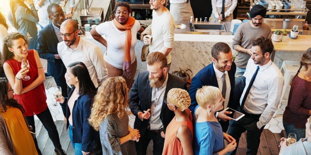 Diverse group at a social event, people mingling and networking. Mixed gender and ethnicity, lively atmosphere, business and casual attire, social gathering. Diverse business people mingle at event.